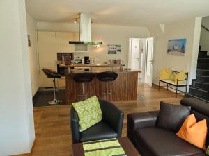 a living room with a couch and a kitchen at Casa Alpina in Goldegg