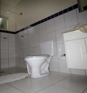 uma casa de banho com um WC branco e um lavatório. em Pousada Encanto da Mata - Ecológica em Caconde