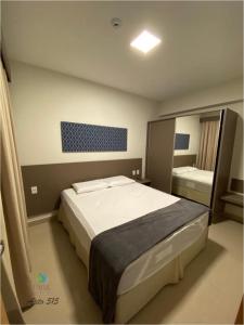 a bedroom with a large bed and a mirror at Flat Park Veredas com Vista Piscina Frigobar e Fogão in Rio Quente +27 photos
