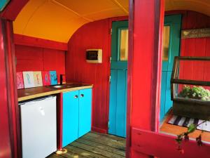 a kitchen with red and blue walls and a counter at La Maison des Oiseaux. Roulotte in Achicourt