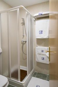 een badkamer met een douche, een toilet en handdoeken bij Pradaria Asador & Alojamiento in Arcas