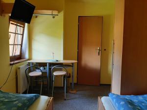 a room with a table and two chairs and a door at Pension Studenov in Rokytnice nad Jizerou