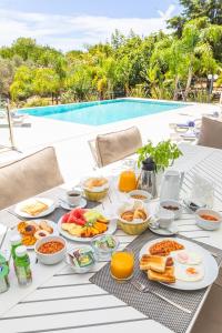 a table with breakfast food on it next to a pool at Fazenda Viegas in Lagos