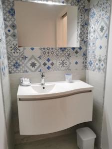 y baño con lavabo blanco y espejo. en Case Vacanza La Pajara, en Leuca