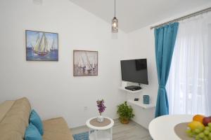 a living room filled with furniture and a tv at J & P Apartments Orahovac in Kotor