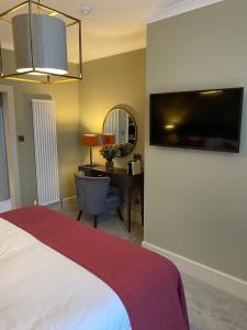 a bedroom with a bed and a desk with a computer at Rooms at the Saint in St. Andrews