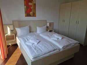 a bed with white sheets and towels on it at Ostseeapartment in Graal-Müritz