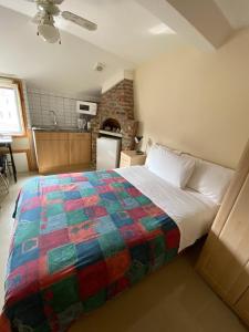 a bedroom with a bed with a colorful quilt on it at Seven Dials Studio in London