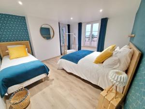 a bedroom with two beds and a mirror at La Maison des Jonquerets in Jonquerets-de-Livet