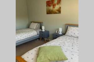 a bedroom with two beds and two night stands at Creag Mhor Self Catering Holiday Apartment in Aberfoyle