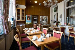 a dining room with wooden tables and chairs at Inselhotel Ihnken in Norderney