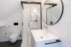 a white bathroom with a sink and a mirror at Hotel-Restaurant Beim Schlass in Wiltz