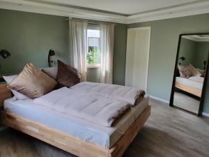 a large bed in a bedroom with a mirror at Moselfeeling co2frei in Cochem