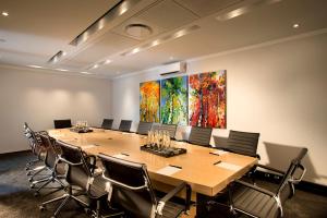 a conference room with a large wooden table and chairs at Max Executive Apartments in Johannesburg