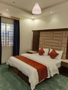 a bedroom with a large bed with a large headboard at فندق الحاتمية in Abha