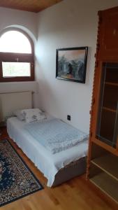 um pequeno quarto com uma cama e uma janela em Anna vendégház em Balatonakali