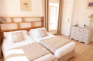 a bedroom with two beds and a dresser at Auberge du Vieux Château in Cabris
