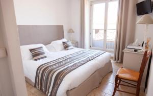 a bedroom with a large bed and a window at Auberge du Vieux Château in Cabris