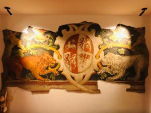 a wall with a painting of lions and a mirror at Hotel Residence Rosa in San Lugano