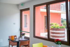 a room with a window with a table and a balcony at Vino e Turismo in San Defedente di Cervasca