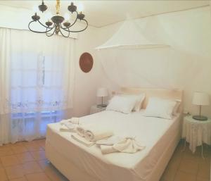 a bedroom with a white bed with towels on it at Μaisonette Deja Bleu in Syvota