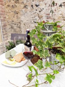 uma garrafa de vinho e um prato de comida numa mesa em My Little Garden -Parking gratuit 500m -Coeur historique -La Clef de Honfleur em Honfleur