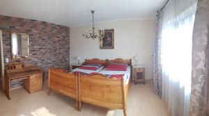a bedroom with a wooden bed and a brick wall at Casa Rustica in Flonheim
