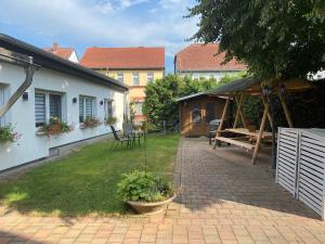 een achtertuin met een picknicktafel en een paviljoen bij Ferienwohnung „Blaues Schild“ in Dorndorf