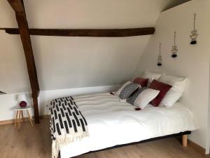 ein Schlafzimmer mit einem weißen Bett in einem Zimmer in der Unterkunft Le charme et l’original in Ailly-le-Haut-Clocher