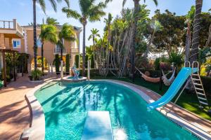 a pool with a slide in a yard with palm trees at Fazenda Viegas in Lagos