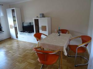 a dining room with a table and orange chairs at Ferienhaus Dampferblick in Meißen