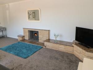 a living room with a fireplace and a flat screen tv at Bankwell Cottage in Newcastle upon Tyne