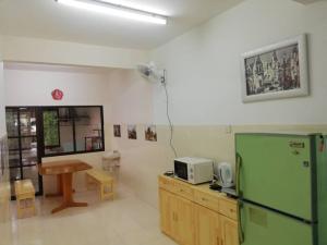 eine Küche mit einem grünen Kühlschrank und einem Tisch in der Unterkunft Sweethome for 7 travellers at seremban in Seremban