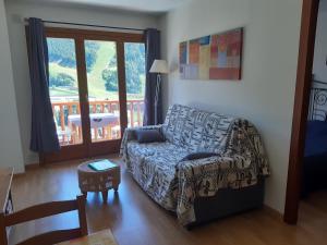 sala de estar con sofá y balcón en Terrasses- Vacances Pirinenca, en El Tarter