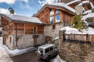 een auto geparkeerd voor een huis in de sneeuw bij Madame Vacances Le Chalet Denali in Val dʼIsère