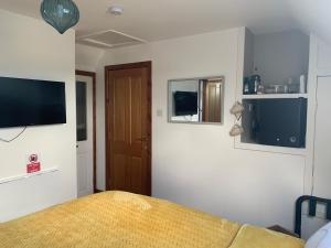 a bedroom with a bed and a television on the wall at Tors Place in Portree