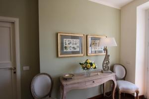 a room with a table with a lamp and chairs at Villa La Moraiola in Passignano sul Trasimeno