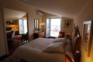 パッシニャーノ・スル・トラジメーノにあるVilla La Moraiolaのベッドルーム(大型ベッド1台付)、リビングルームが備わります。