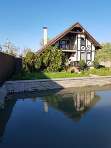 une maison avec une réflexion dans un corps d'eau dans l'établissement Guest House on Lesnaya, à Leski