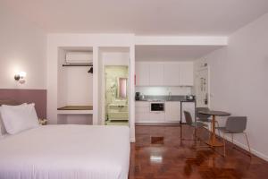 里斯本Lisbon Serviced Apartments - Campos的一间带白色床的卧室和一间厨房
