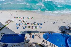 einen Blick über den Strand mit Stühlen und Sonnenschirmen in der Unterkunft Ocean Dream Cancun by GuruHotel in Cancún