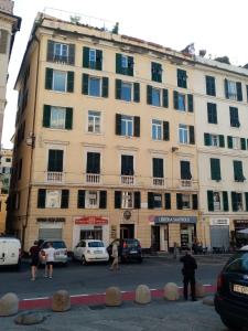 un gran edificio con coches estacionados frente a él en bed and breakfast " La Terrazza", en Génova