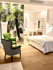 トラーニにあるB&B Al Vicoのベッドルーム1室(ベッド1台、椅子、ヤシの木の壁画付)