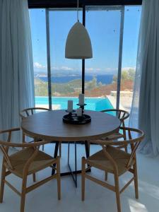 a table with two chairs and a lamp in a room at The Cove Sivota Bay in Sivota