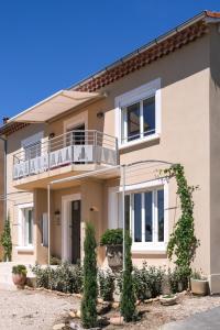 une maison avec un balcon sur le côté dans l'établissement La Maison Ryokufu, à Châteauneuf-du-Pape