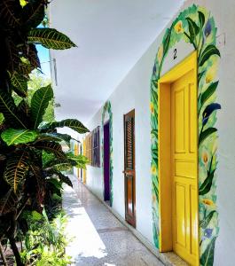 a hallway of a building with colorful doors and plants at Hotel Posada Edem in Cozumel