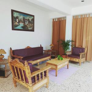 un soggiorno con divani, sedie e tavolo di Hotel Posada Edem a Cozumel