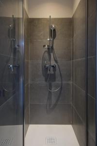 une douche avec une porte vitrée dans une salle de bain dans l'établissement La Maison Ryokufu, à Châteauneuf-du-Pape