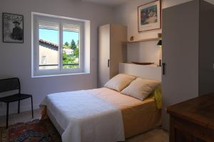 une chambre avec un lit et une fenêtre dans l'établissement La Maison Ryokufu, à Châteauneuf-du-Pape 29 autres photos