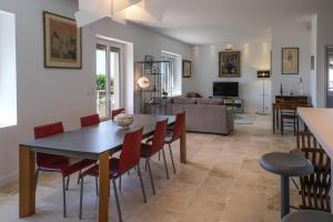 une salle à manger et un salon avec une table et des chaises dans l'établissement La Maison Ryokufu, à Châteauneuf-du-Pape